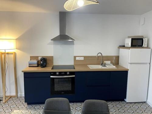 una cucina con isola blu, lavandino e piano cottura di Séjour de charme au marais bleu a Amboise