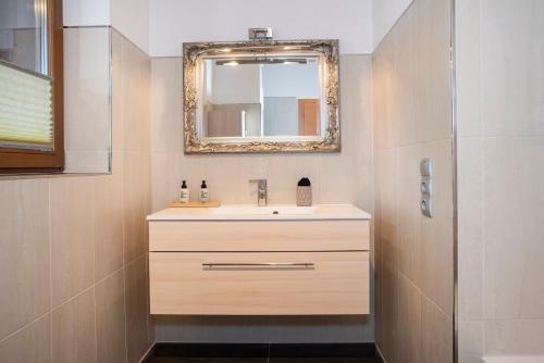a bathroom with a sink and a mirror at Natural Deluxe Apartments Alpbach in Alpbach