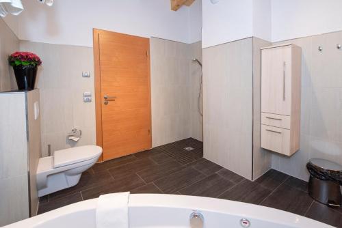 a bathroom with a toilet and a bath tub at Natural Deluxe Apartments Alpbach in Alpbach