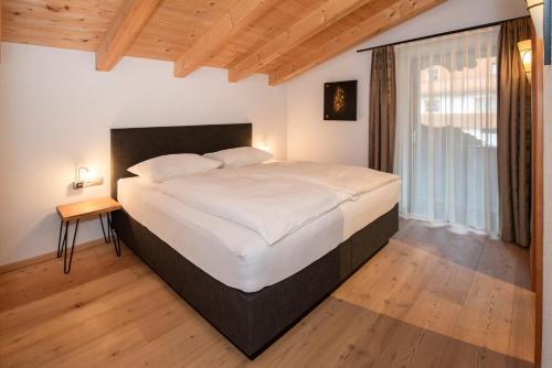 una camera con un grande letto e una finestra di Natural Deluxe Apartments Alpbach ad Alpbach