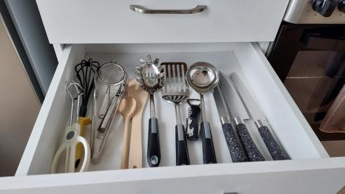 a drawer filled with utensils in a kitchen at MINA modern & cozy apartment main city square GTC Skopje in Skopje