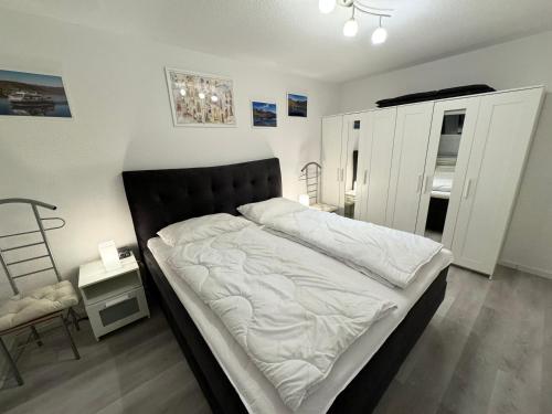 Schlafzimmer mit einem großen Bett mit einem schwarzen Kopfteil in der Unterkunft Ferienwohnung Schönfeld auf Fehmarn in Petersdorf auf Fehmarn