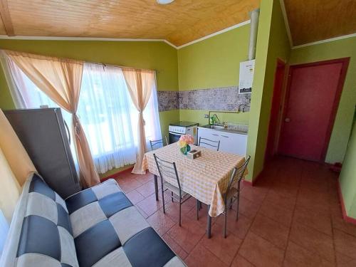 uma cozinha com mesa e cadeiras num quarto em Cabaña a pasos de la Playa em Puerto Montt