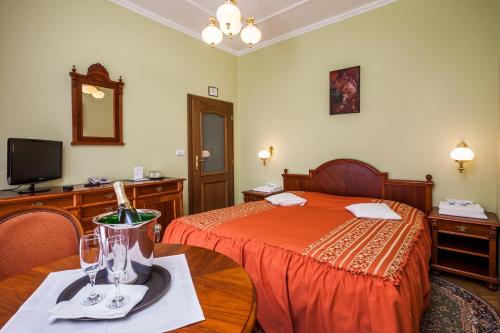 a hotel room with a bed and a table with a table sidx sidx at Hotel Jelínkova vila in Velké Meziříčí