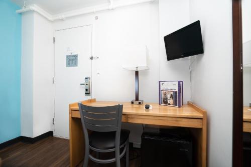 a room with a desk with a television and a chair at West Side YMCA in New York