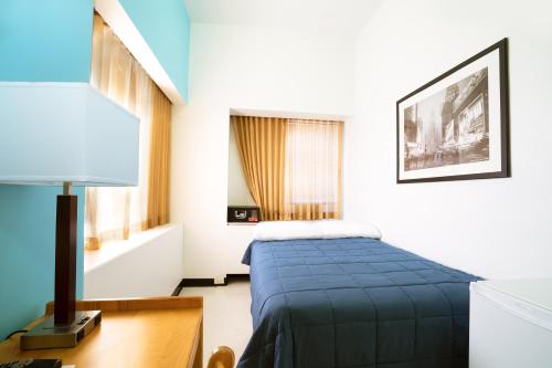a bedroom with a bed and a lamp on a desk at West Side YMCA in New York
