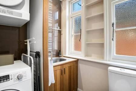 uma cozinha com um lavatório e uma máquina de lavar roupa em Charming inner city home excellent base in Hobart em Hobart