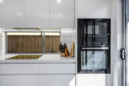 a kitchen with a sink and a stove top oven at New Mod Home 2 bed bath Home 12km to CBD Airport in Rokeby