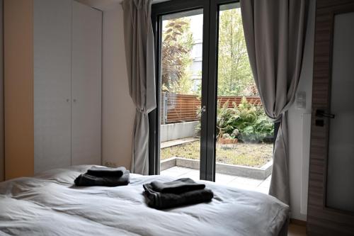 two towels sitting on a bed in front of a window at Lovely Family Suite in Prague