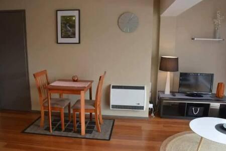 sala de estar con mesa, sillas y microondas en Modern 1 bed-walk Casino riverfront 5 mins to CBD en Hobart