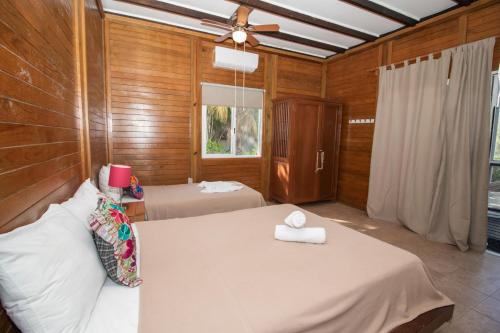a bedroom with two beds and a ceiling fan at Hotel Encanto Holbox Beach Front in Holbox Island