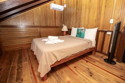 a bedroom with a bed in a room with wooden floors at Hotel Encanto Holbox Beach Front in Holbox Island