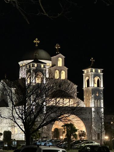 a large building with a clock tower at night at Podgorica Great location in Podgorica