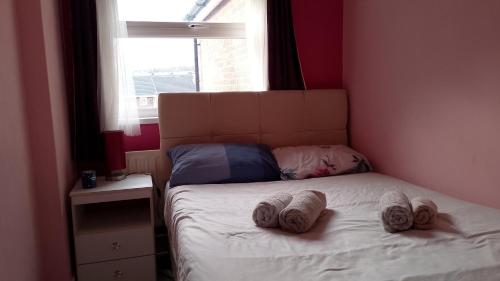 a bedroom with a bed with two pairs of slippers on it at Iris House in Belfast