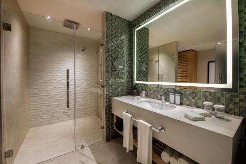 a bathroom with a sink and a glass shower at Unique Club at Lopesan Costa Bávaro Resort in Punta Cana