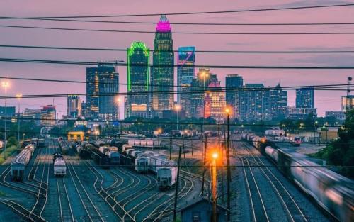 a city skyline at night with trains on tracks at Modern 1BD Studio Apt in Plaza Midwood with Community Pool in Charlotte
