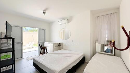 ein Schlafzimmer mit zwei Betten und einem Fenster in der Unterkunft Casa Mar & Brisa - Wi-fi e piscina in Guaratuba