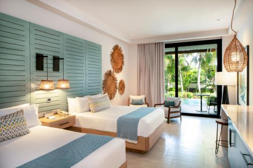 a bedroom with two beds and a living room at Unique Club at Lopesan Costa Bávaro Resort in Punta Cana