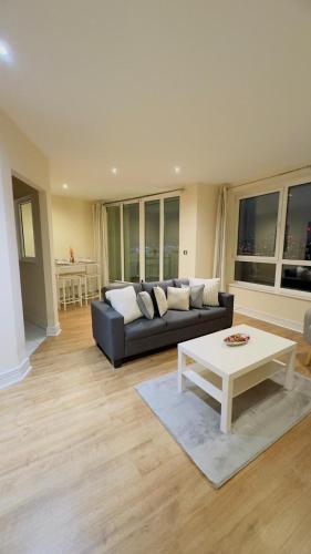 een woonkamer met een bank en een salontafel bij Modern 2 Bedroom Apartment- Royal Docks - London City Airport in Londen