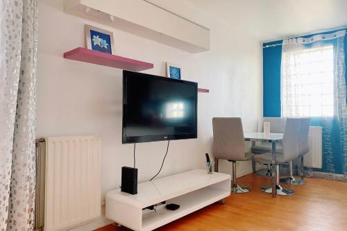 a living room with a flat screen tv on a wall at Comfortable 50 m apartment with parking in Courbevoie