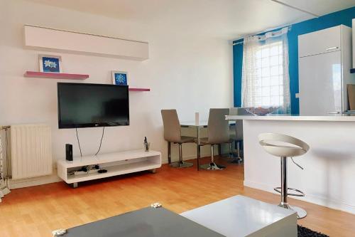 - un salon avec une télévision et une table dans l'établissement Comfortable 50 m apartment with parking, à Courbevoie