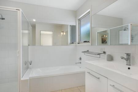 Baño blanco con 2 lavabos y espejo en The Rest Retreat Getaway 15 Mins to CBD 3 Bed en Hobart