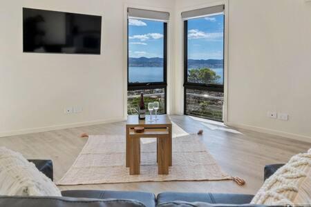 サンディ・ベイにあるThe View Studio Apartment Fully self-contained Sandy Bayのリビングルーム(テーブル、大きな窓付)