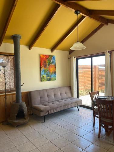 sala de estar con sofá y chimenea en Cabañas y departamento cerca en primera línea de la playa, en Punta de Choros