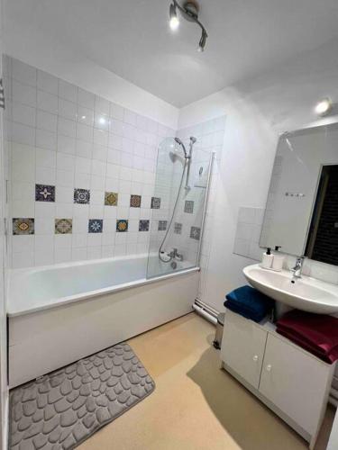 une salle de bain avec une baignoire, un lavabo et une douche dans l'établissement Ulis très beau 2 pièces tout équipé, aux Ulis