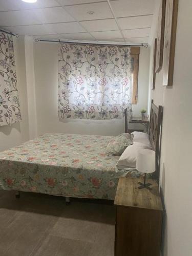 a bedroom with a bed and a window with curtains at Ca' La Conchin in Cortez de Pallas