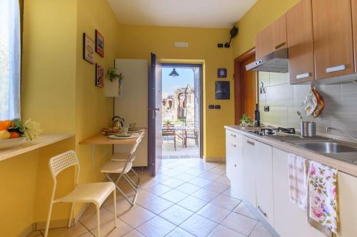 une cuisine avec des murs jaunes et des armoires blanches dans l'établissement Casa vacanze Antica Capua, à Santa Maria Capua Vetere