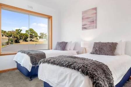 a bedroom with two beds and a large window at Residence at 165 Great for large groups Sleeps 11 in Hobart