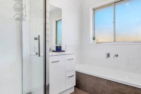 a white bathroom with a shower and a sink at Residence at 165 Great for large groups Sleeps 11 in Hobart