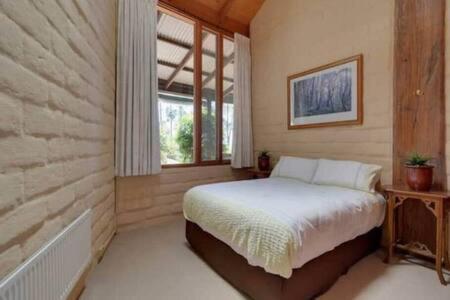 a bedroom with a white bed and a window at Tinderbox Cliff House - Waterside Private Retreat in Hobart