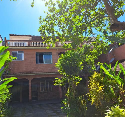 a red brick house with a lot of trees at Casa Costa Verde-Muriqui in Vila Muriqui