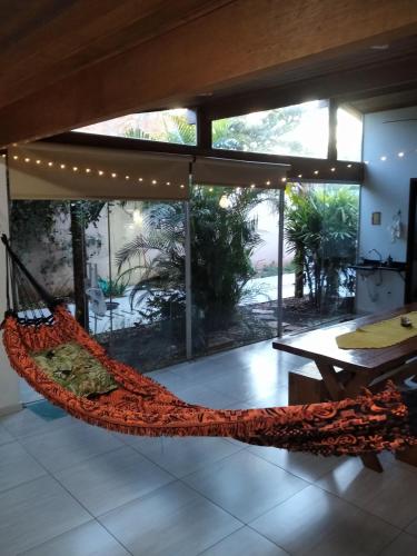 a hammock in a room with a large window at CASA INTEIRA MOBILIADA Próx Shopping Norte com Ar e Wifi , Selfie Checkin e Tv FireAmazon in Londrina