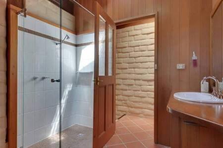 a bathroom with a shower and a sink at Tinderbox Cliff House - Waterside Private Retreat in Hobart