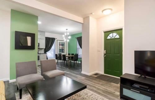 a living room with a green door and a table at Housepitality - The Mint Julep House in Columbus