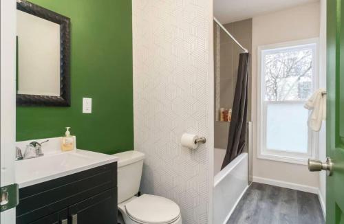 uma casa de banho verde com um WC e um lavatório em Housepitality - The Mint Julep House em Columbus