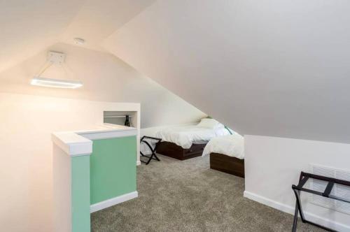 a attic room with two beds and a desk at Housepitality - The Mint Julep House in Columbus