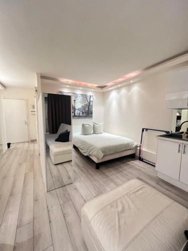 Cette grande chambre blanche dispose d'un lit et d'une cuisine. dans l'établissement Apartment Like HOME Arc de Triomphe, Champs Élysées, Tour Eiffel, à Paris