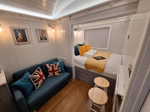 a small bedroom with a bed and a couch at Whiskers and Woods Shepherd Hut 