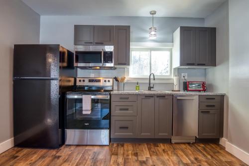 a kitchen with stainless steel appliances and wooden floors at 1st Floor - Adventure Property in Whitefield