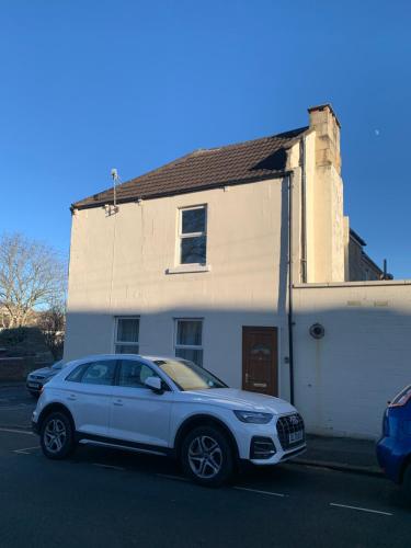 a white car parked in front of a white building at The Caledonian House in Bath