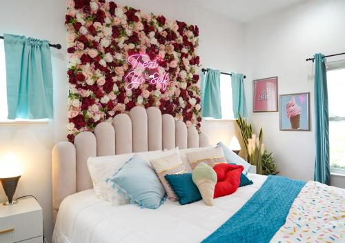 um quarto com uma grande cama branca com almofadas coloridas em Ice Cream Retreat at Casa Kumwesu em Bellmead