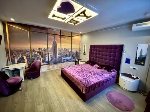 a bedroom with a purple bed and a large window at Complex Khutor in Velyka Omelyana