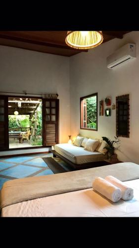 a bedroom with two beds and a large window at Dellacasa in Jericoacoara