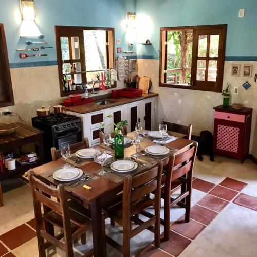 a kitchen with a wooden table with plates and glasses on it at Dellacasa in Jericoacoara