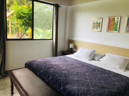 a bedroom with a large bed and a window at Las Cabañas in Olón