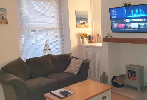 a living room with a couch and a flat screen tv at Eden Rose Cottage in Morecambe